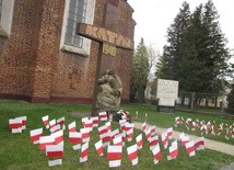 96 białoczerwonych flag przy krzyżu katyńskim, nieopodal kościoła ojców pasjonistów w Przasnyszu