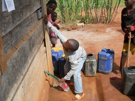  Dzieci z misji czerpią wodę obsługując wodomat
