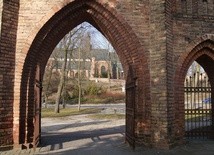 Widok na najstarszą część Ciechanowa - Farską Górę i kościół NMP - z neogotyckiej bramy przy kościele poaugustiańskim