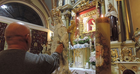 Wierni w osobistej modlitwie przed figurą św. Michała Archanioła