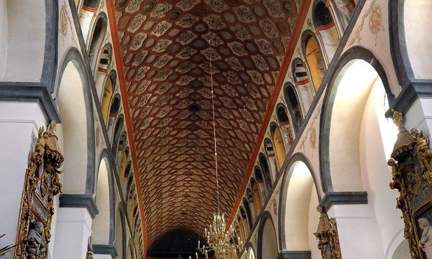 Wnętrze bazyliki pułtuskiej zwieńczone sklepieniem kolebkowym, z charakterystyczną dekoracją architektoniczną i polichromią