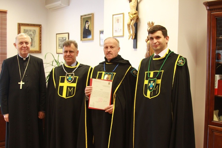 Bp Piotr Libera wręcza Rycerzom Jana Pawła II dekret zezwalający na działalność w diecezji płockiej.